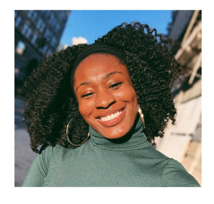 A brown skinned woman in a green turtleneck